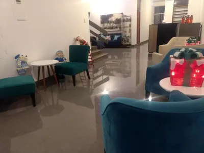 a living room with blue chairs and a table at Regency Plaza Hotel in Pisco