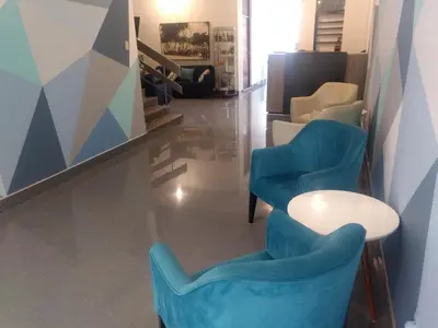 a room with two blue chairs and a table at Regency Plaza Hotel in Pisco