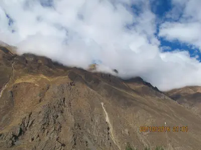 a mountain with clouds on top of it at Tumy house B&B in Ollantaytambo