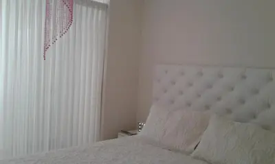 a bedroom with a white bed and a window at Edificio California en Centro Historico in Lima