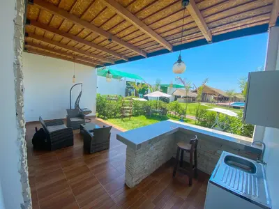 a patio with a bar with a view of a yard at Hotel Resort Thiago in Chincha Alta
