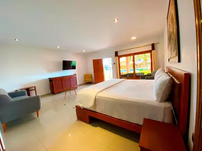 a bedroom with a large bed and a couch and a chair at Hotel Resort Thiago in Chincha Alta