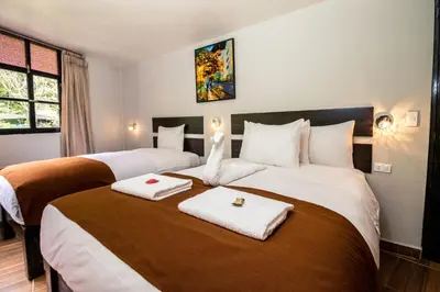 a hotel room with two beds with towels on them at Samananchis Machupicchu in Machu Picchu
