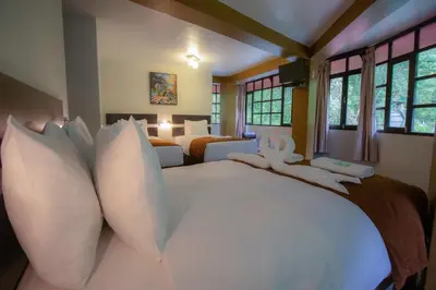 a large bedroom with two beds with white pillows at Samananchis Machupicchu in Machu Picchu