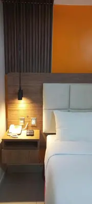 a bedroom with a bed and a desk with a phone at Residencial Alfa Hotel in Lima