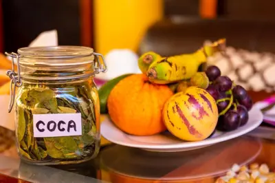 a plate of fruit on a table with a jar of salsa at Peru Quechua's Lodge Ollantaytambo in Ollantaytambo