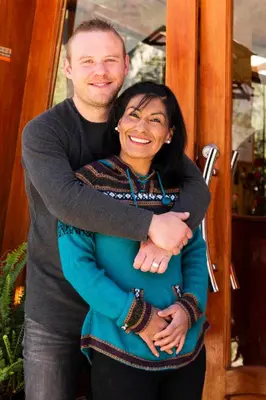 a man and a woman hugging in front of a door at Peru Quechua's Lodge Ollantaytambo in Ollantaytambo