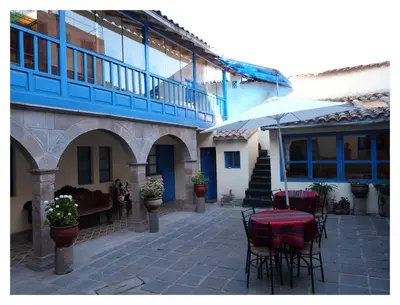 a patio with a table and chairs in front of a building at Chaquill Chak'a in Cusco