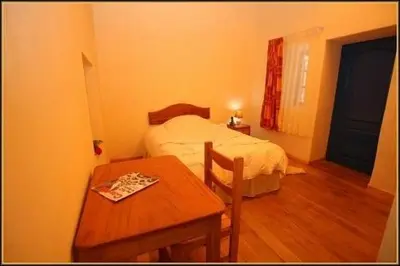 a small bedroom with a bed and a table at Chaquill Chak'a in Cusco