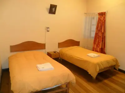 a room with two beds and a window at Chaquill Chak'a in Cusco