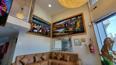 a living room with a couch and posters on the wall at Hotel Wanka Palace in Huancayo
