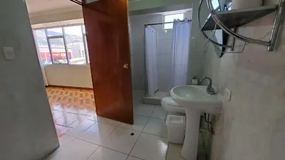 a bathroom with a sink and a toilet and a window at Hotel Wanka Palace in Huancayo