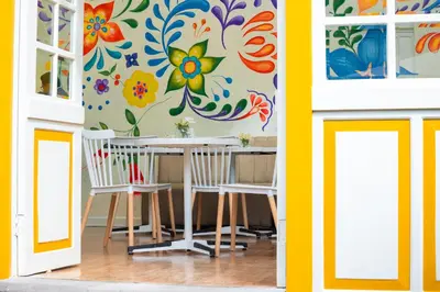 a dining room with a table and chairs and a colorful wall at 7 Toritos Hotel Boutique by Hacienda in Cusco