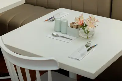 a white table with a vase of flowers on it at 7 Toritos Hotel Boutique by Hacienda in Cusco