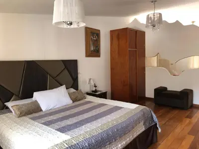 a bedroom with a large bed and a chair at Hotel de Turistas Abancay in Abancay