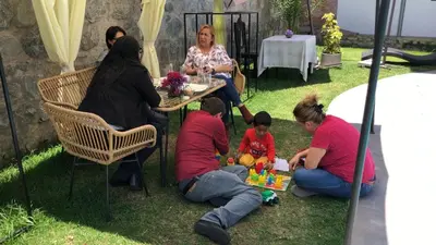 a group of people sitting in the grass playing with toys at Hotel de Turistas Abancay in Abancay