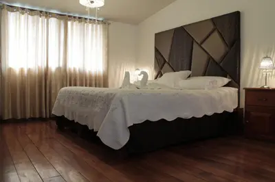 a bedroom with a large bed with white pillows at Hotel de Turistas Abancay in Abancay
