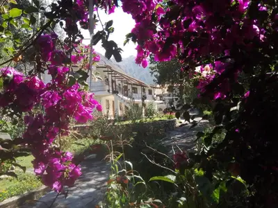 a garden with purple flowers in front of a building at Casa de Mama Valle - Urubamba in Urubamba