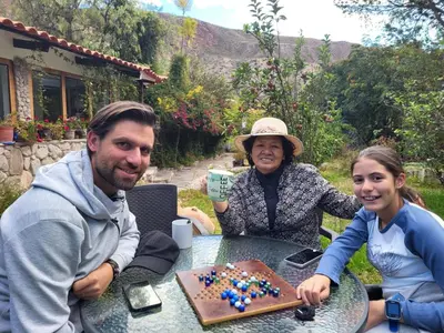 a man and a woman sitting at a table with a cake at Casa de Mama Valle - Urubamba in Urubamba