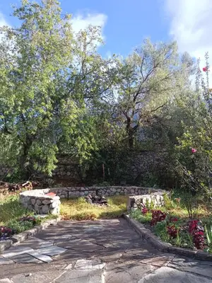 a stone path in a garden with trees and flowers at Casa de Mama Valle - Urubamba in Urubamba