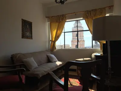 a living room with a couch and a large window at Best place in Plaza Mayor Lima, Pizarro building in Lima