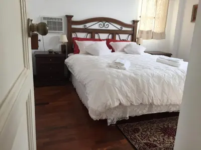 a bedroom with a bed with white sheets and red pillows at Best place in Plaza Mayor Lima, Pizarro building in Lima