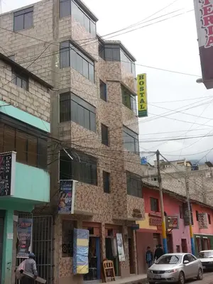 a tall stone building on a city street at Hostal Arcangel in Abancay