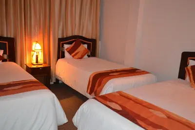 a hotel room with two beds and a lamp at Andino Classic in Machu Picchu