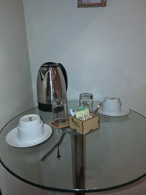 a glass table with a tea pot and plates on it at Andino Classic in Machu Picchu