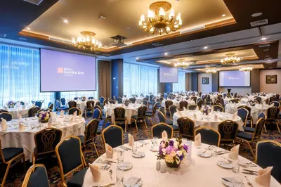a conference room with tables and chairs and a projection screen at Hilton Garden Inn Lima Surco in Lima