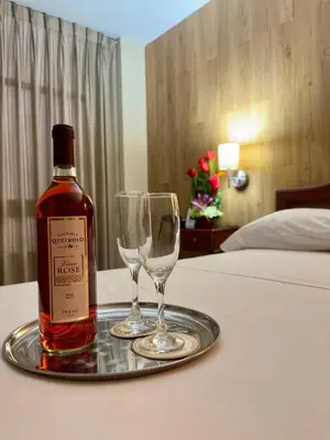 a bottle of wine and two wine glasses on a tray at Hotel Asturias Inn in Lima