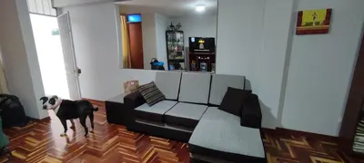 a dog standing in a living room with a couch at Apartamento Marco Airport in Lima