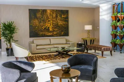 a living room with a couch and chairs and a painting at Jose Antonio Deluxe in Lima