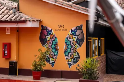 two masks painted on the side of a building at Wild Rover Cusco in Cusco