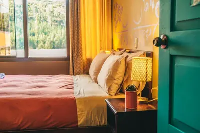 a bedroom with a bed with a window and a table at Wild Rover Cusco in Cusco