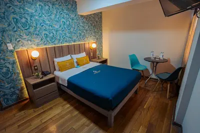 a bedroom with a bed and a table and chairs at Golden Mar Hotel in Lima