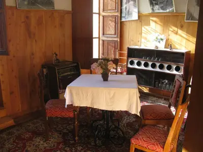 a kitchen with a table and a stove and a table and chairs at Hotel Museo Casona Ugarte Leon in Concepción