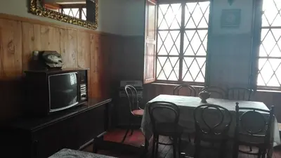 a dining room with a table and a tv at Hotel Museo Casona Ugarte Leon in Concepción