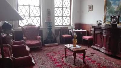 a living room with chairs and a table and a room with a table at Hotel Museo Casona Ugarte Leon in Concepción