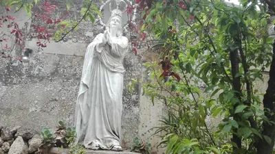a statue of a woman standing in a garden at Hotel Museo Casona Ugarte Leon in Concepción