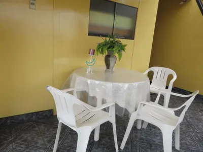 a table with white chairs and a vase with a plant on it at Hospedaje Del Pilar en Magdalena del Mar in Lima