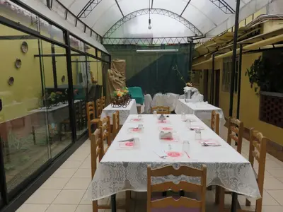 a dining room with tables and chairs and windows at Hospedaje Del Pilar en Magdalena del Mar in Lima