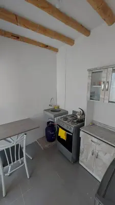 a kitchen with a stove and a table in it at El Capricho Paracas in Paracas