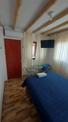 a bedroom with a blue bed and a glass table at El Capricho Paracas in Paracas
