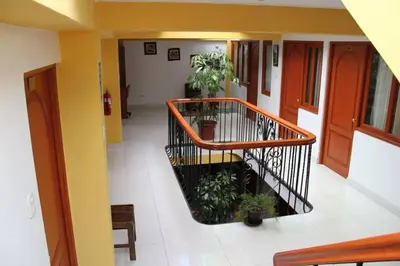 a hallway with a spiral staircase in a building with plants at Tierra del Inka in Cusco