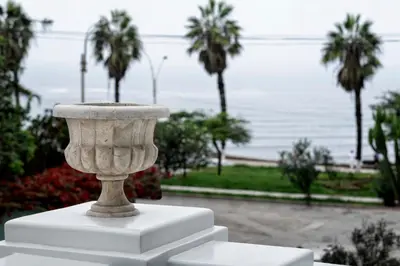 a stone vase sitting on top of a white table at Villa Barranco by Ananay Hotels in Lima