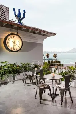 a clock on a wall with chairs and a table at Villa Barranco by Ananay Hotels in Lima