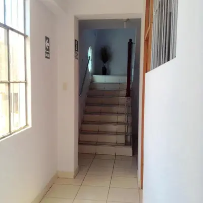 a hallway with a staircase in a house with a window at Hostal La Estancia in Ica