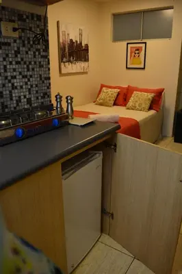 a small kitchen with a bed in a room at Kangaroo Wasi Airport Bed & Breakfast in Lima