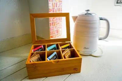 a wooden box filled with packets of toothpaste next to a jug at Apart Hotel Petit Palace Suites in Lima